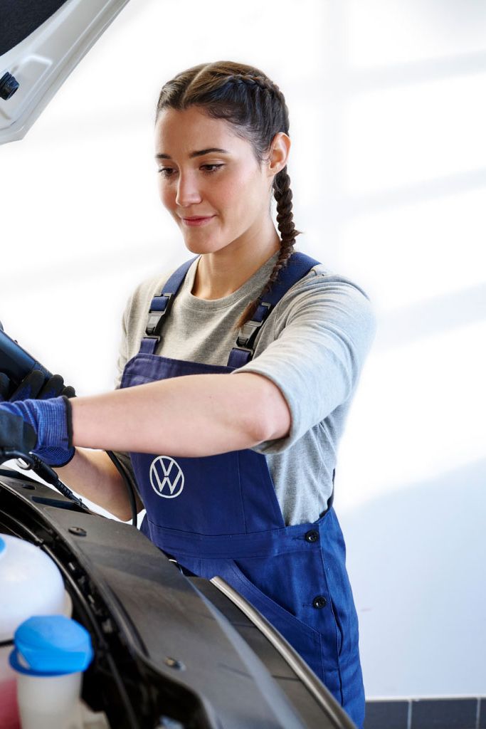 Eine Volkswagen Technikerin überprüft eine Starterbatterie