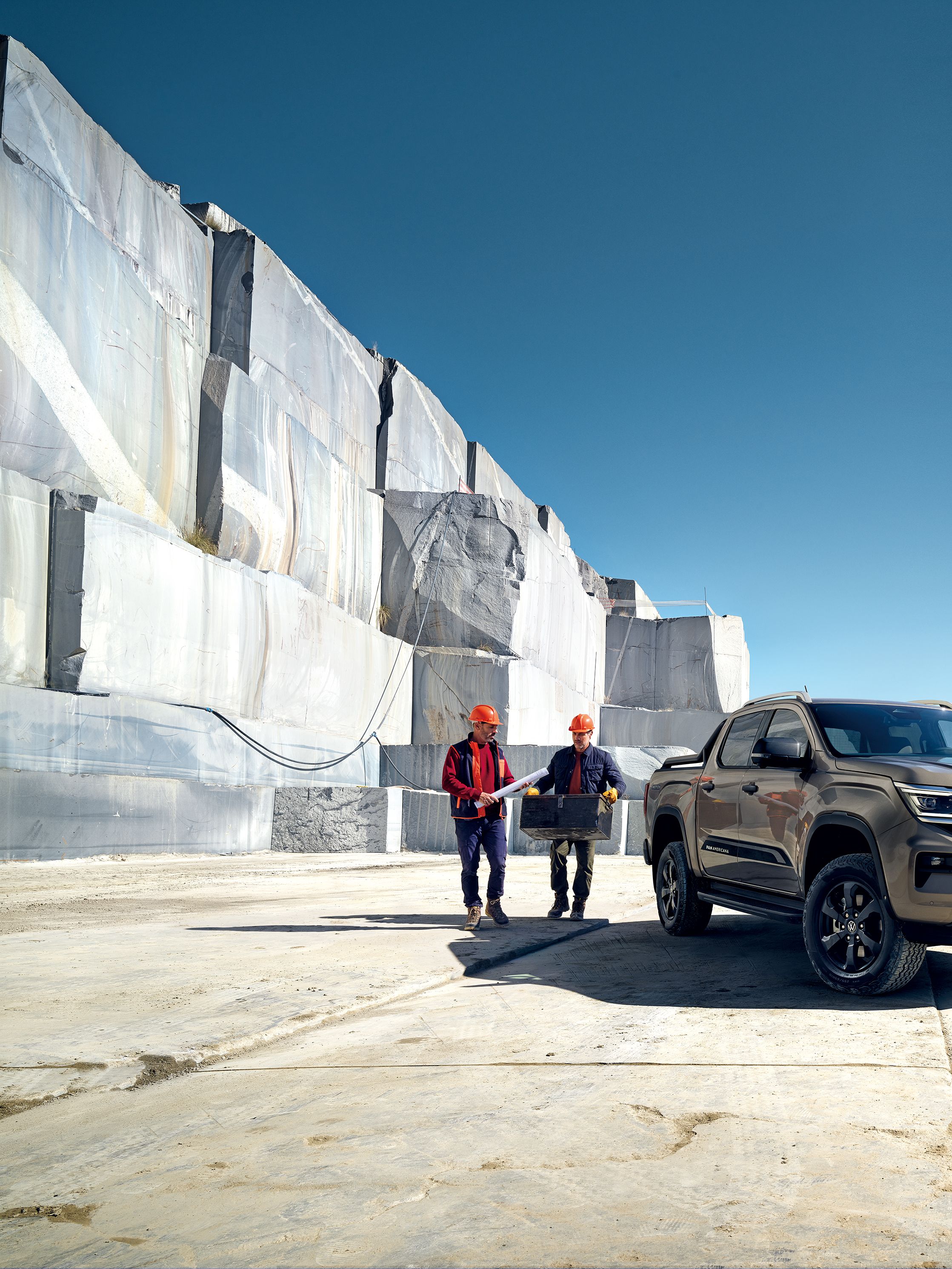 Zwei Arbeiter stehen neben dem neuen VW Amarok