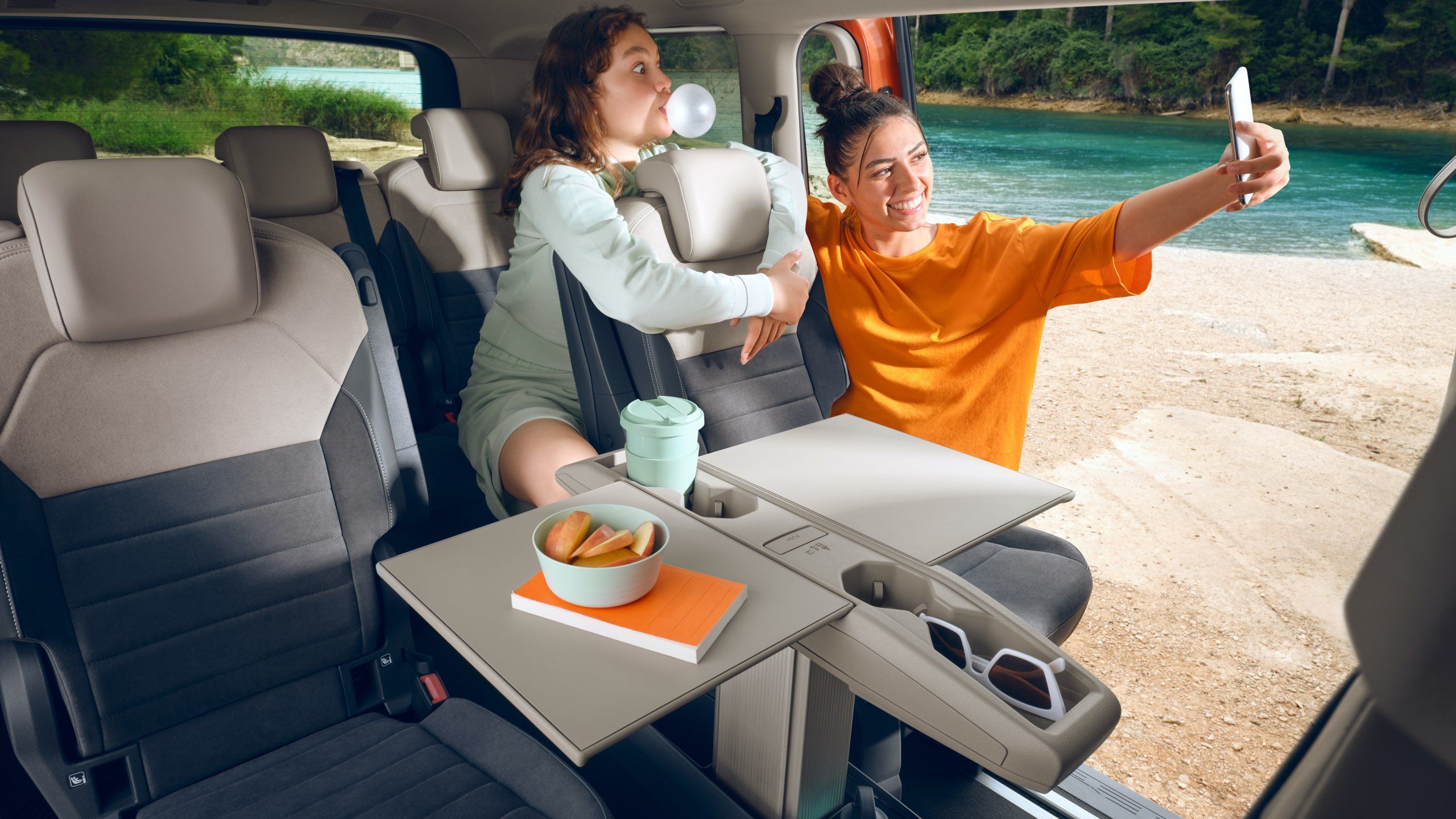 Mutter und Kind machen ein Selfie im Fond des neuen Multivans