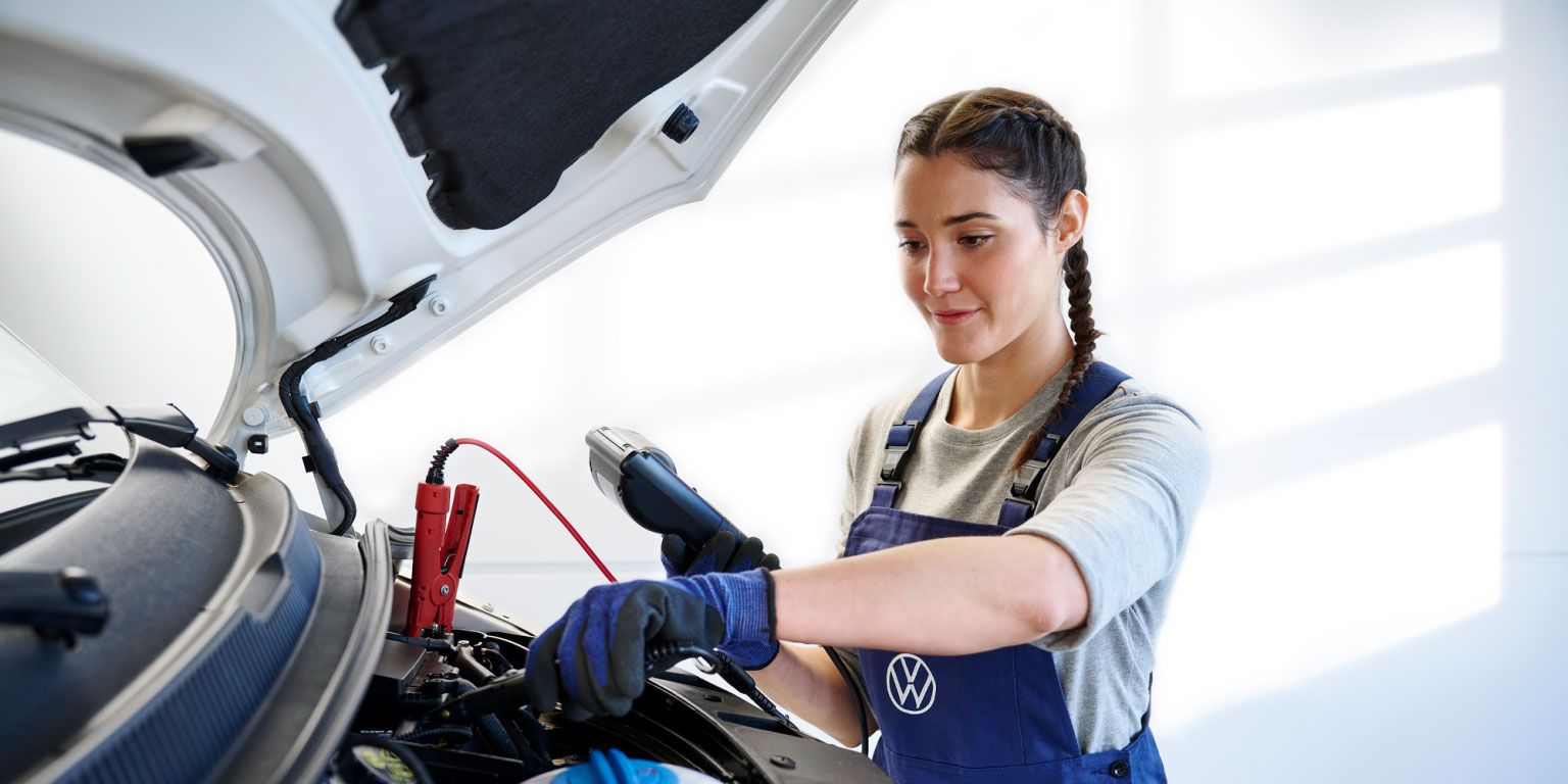 Eine Volkswagen Technikerin überprüft eine Starterbatterie