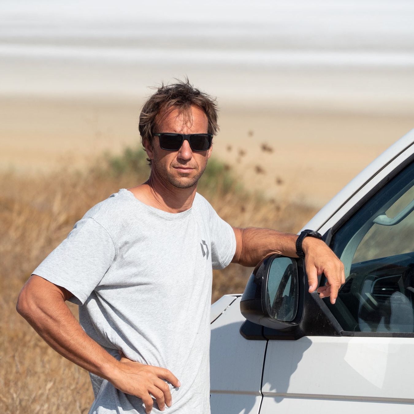 Nahaufnahme Chris Sammer neben seinem VW California Beach