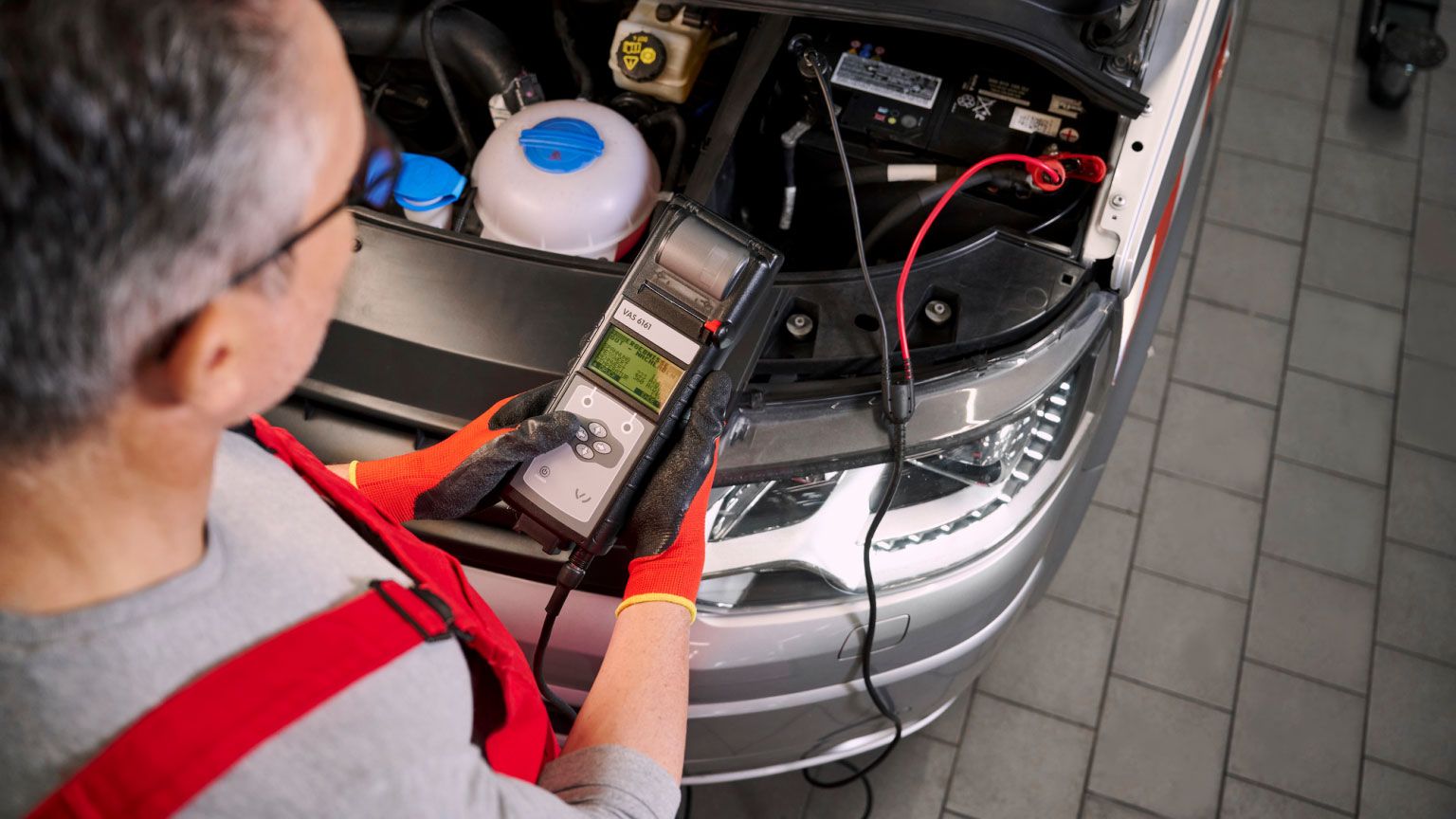 Ein Volkswagen Techniker überprüft eine Starterbatterie