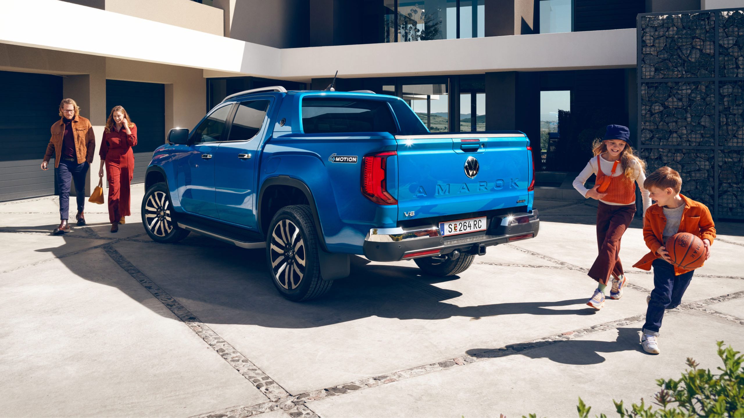 Eine Familie bewegt sich um den VW Amarok