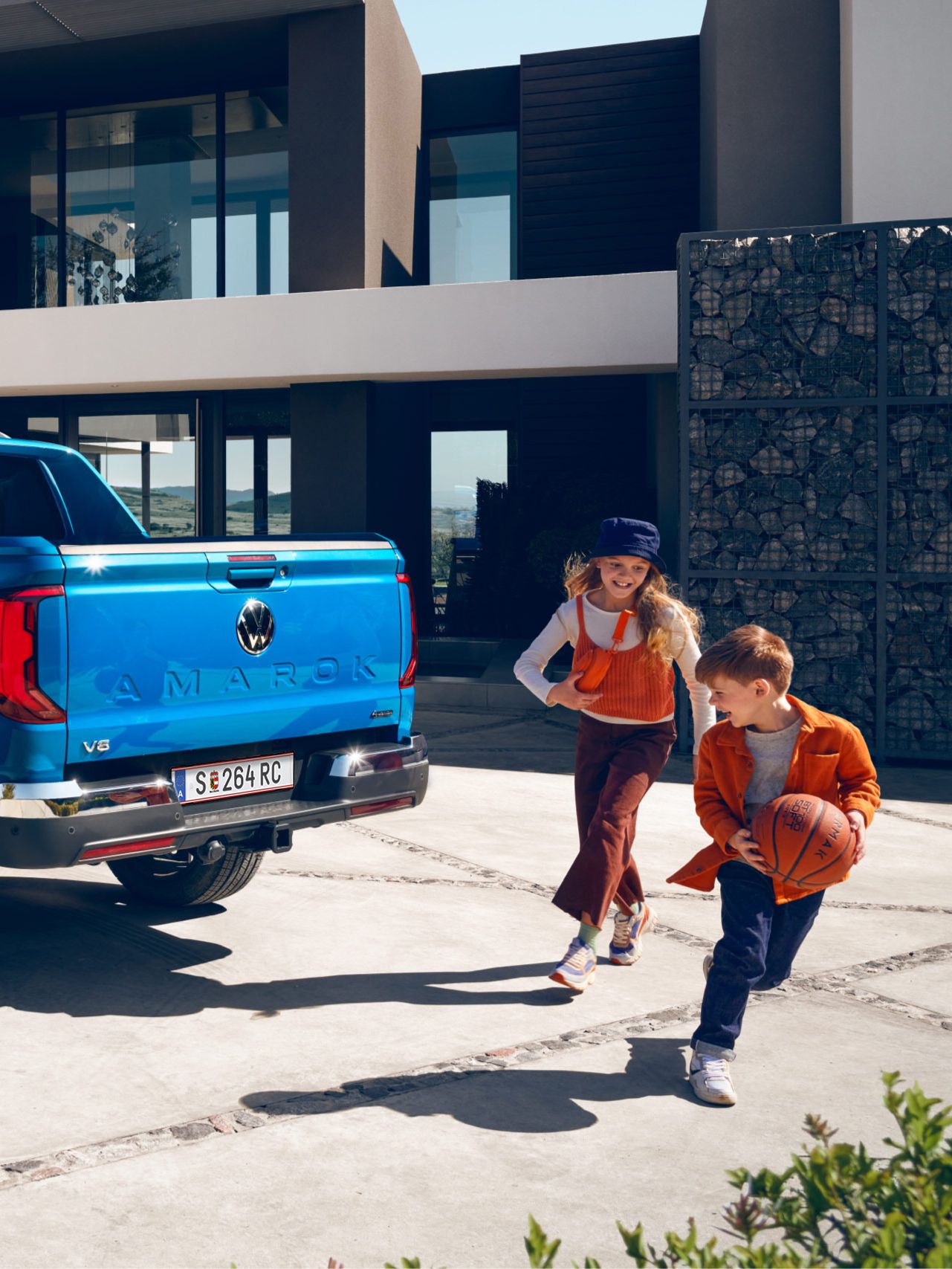 Eine Familie bewegt sich um den VW Amarok